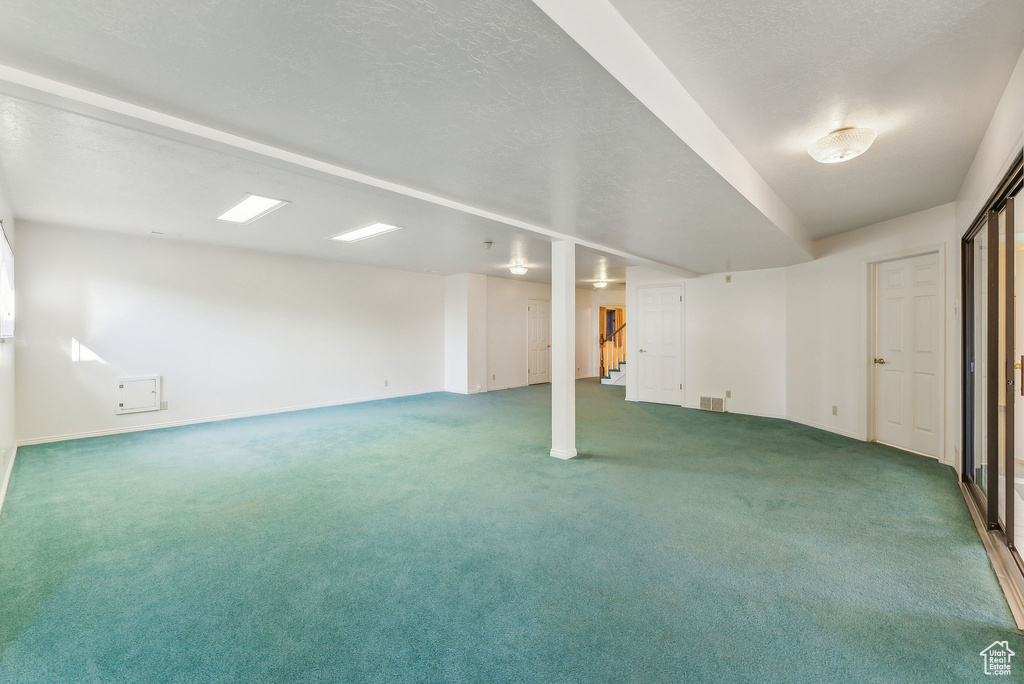 Basement with carpet floors and a textured ceiling