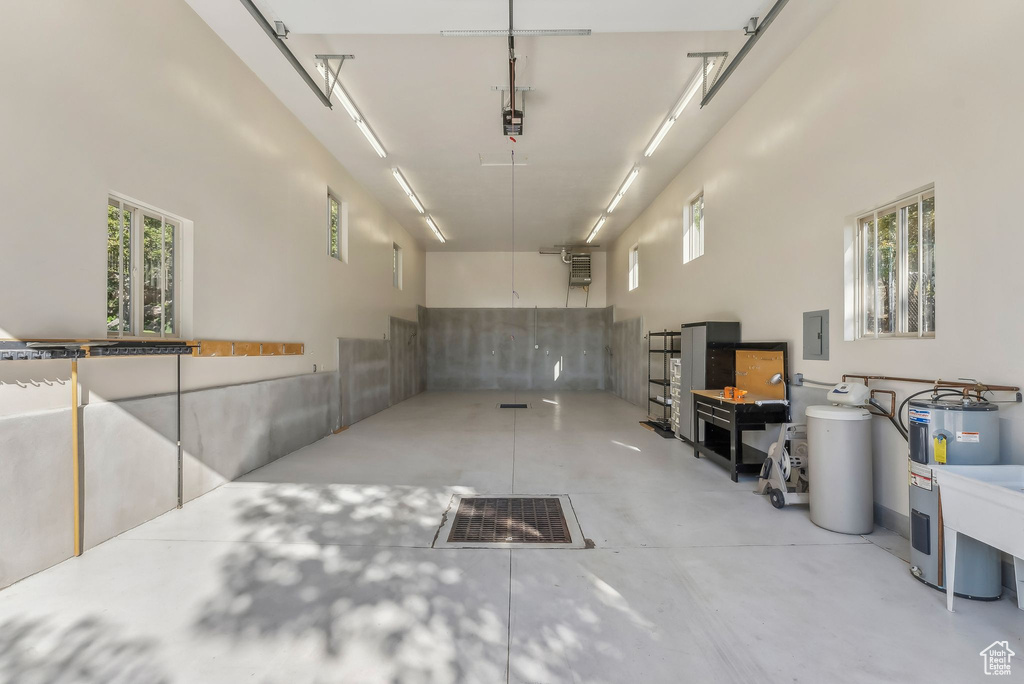 Basement with plenty of natural light, electric panel, and water heater