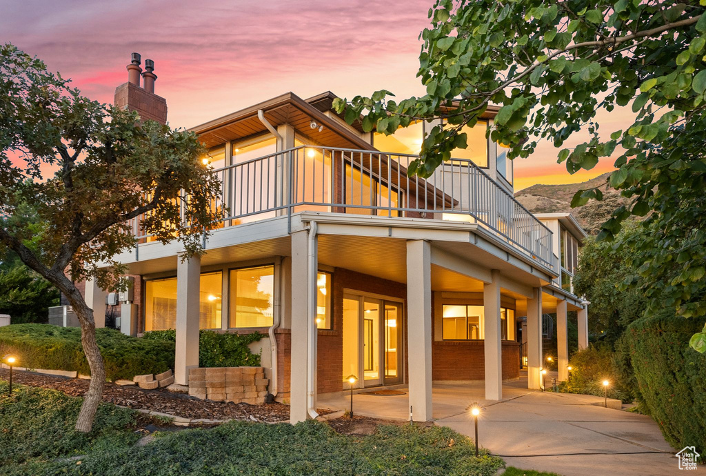 Back house at dusk featuring a patio