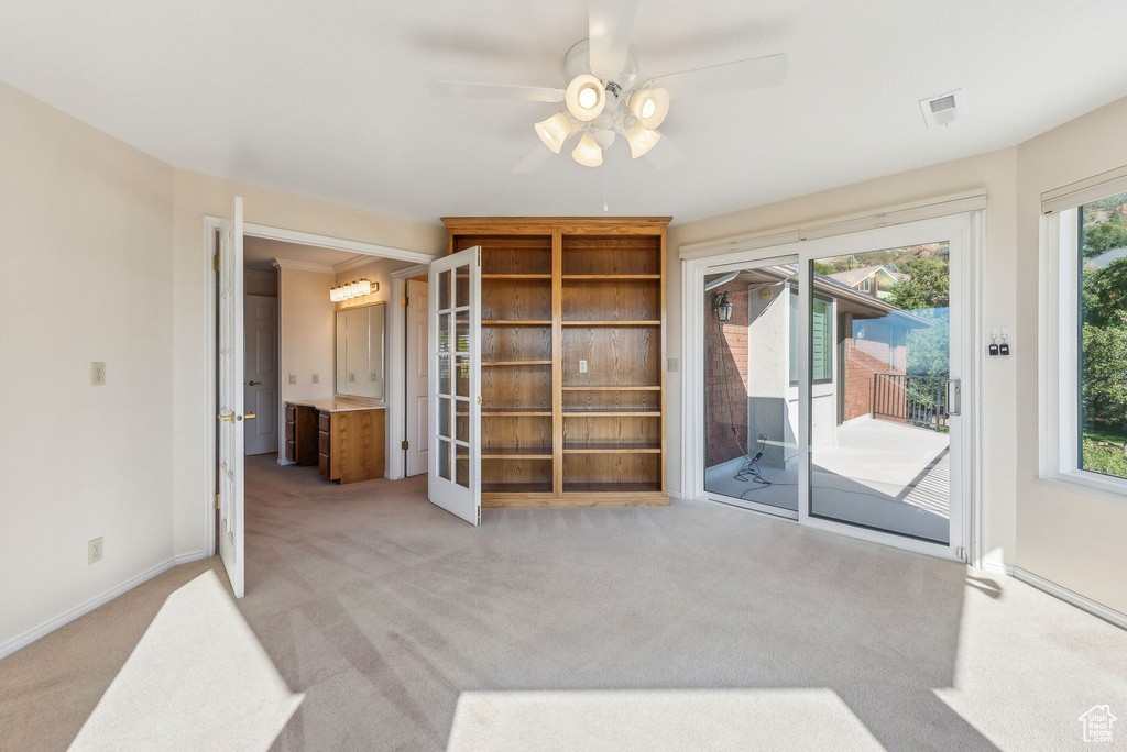 Interior space featuring ceiling fan, plenty of natural light, and light colored carpet