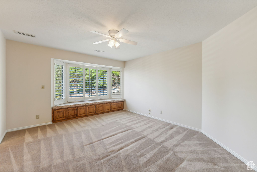 Carpeted spare room with ceiling fan