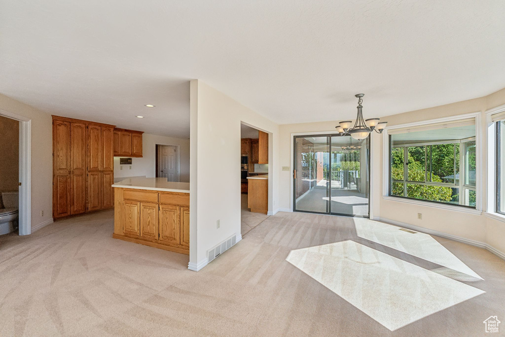 Kitchen featuring light carpet, decorative light fixtures, and a chandelier