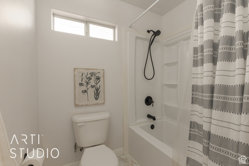 Bathroom with shower / bath combination with curtain and toilet