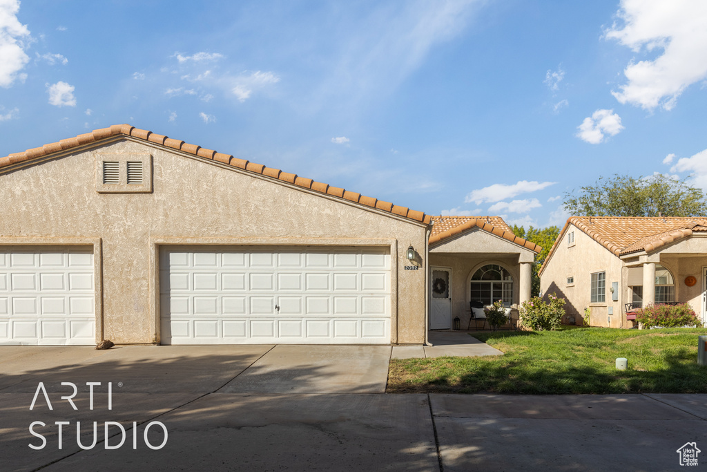 Mediterranean / spanish-style house with a front lawn and a garage