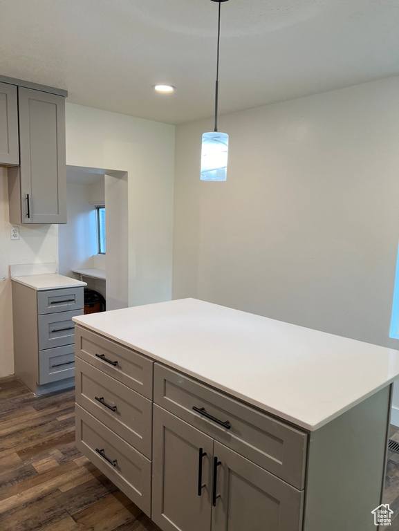 Kitchen with gray cabinets, pendant lighting, and dark wood-type flooring