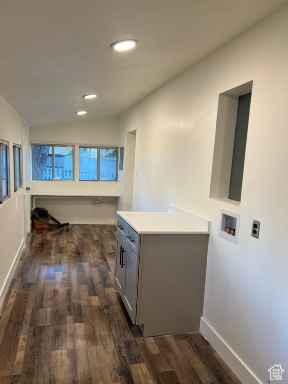 Clothes washing area featuring hookup for a washing machine, dark hardwood / wood-style floors, and cabinets