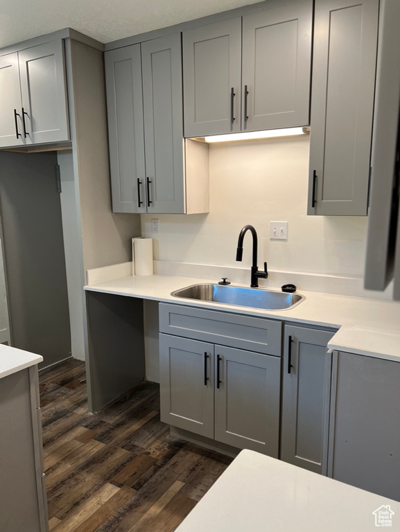 Kitchen featuring gray cabinets, a textured ceiling, sink, and dark hardwood / wood-style flooring