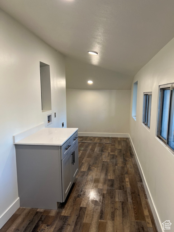 Kitchen with vaulted ceiling, dark wood-type flooring, and gray cabinets