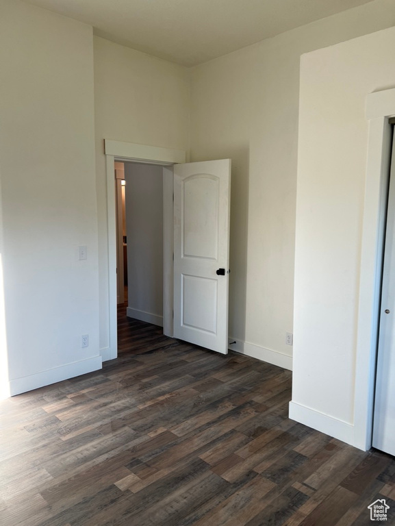 Empty room with dark hardwood / wood-style flooring