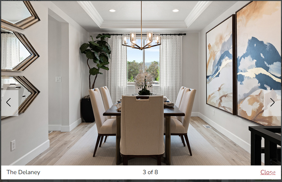 Dining area featuring a notable chandelier, light wood-type flooring, crown molding, and a tray ceiling