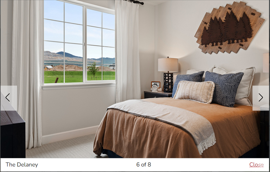 Carpeted bedroom with multiple windows and a mountain view