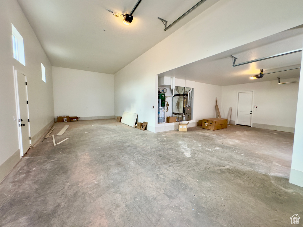 Unfurnished living room featuring concrete flooring and strapped water heater