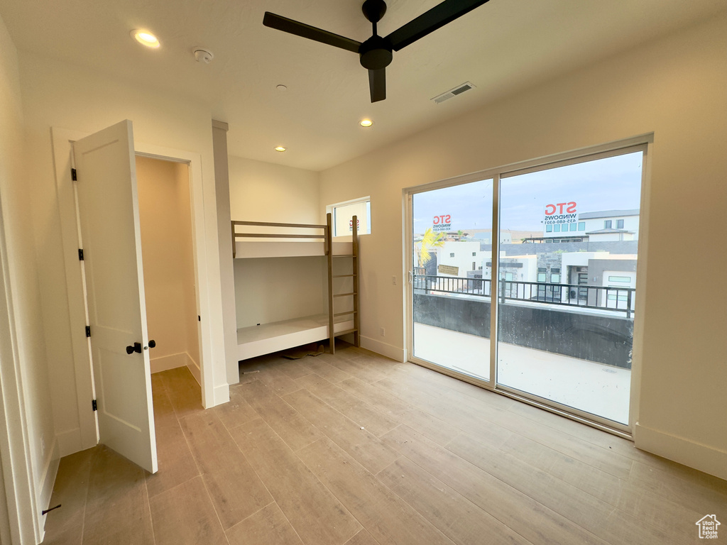 Unfurnished bedroom with ceiling fan, light hardwood / wood-style floors, and access to exterior