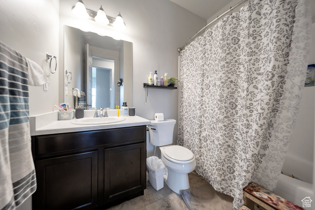 Full bathroom with shower / tub combo, vanity, and toilet