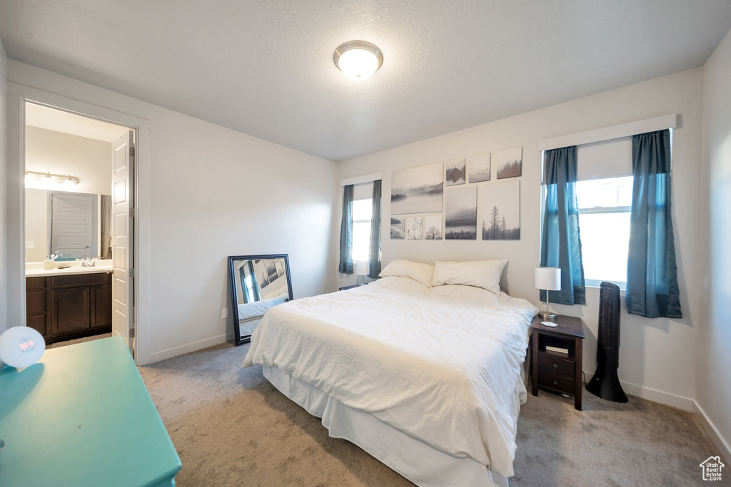 Carpeted bedroom with connected bathroom and a textured ceiling