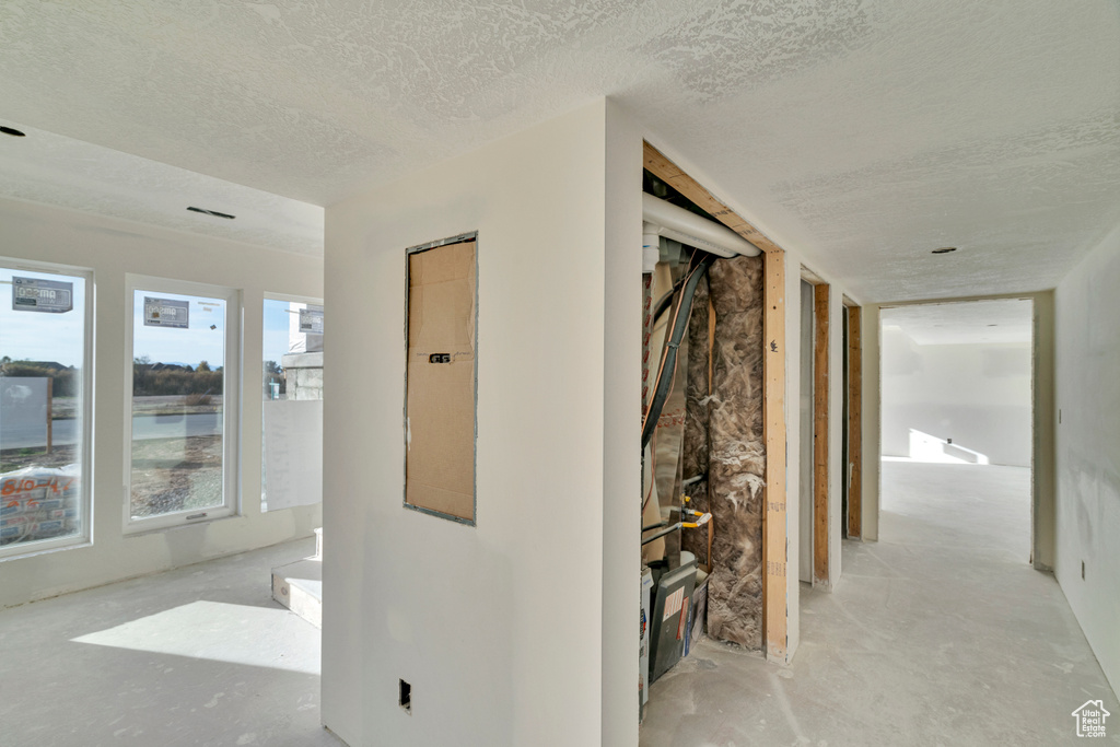 Corridor featuring a textured ceiling and electric panel