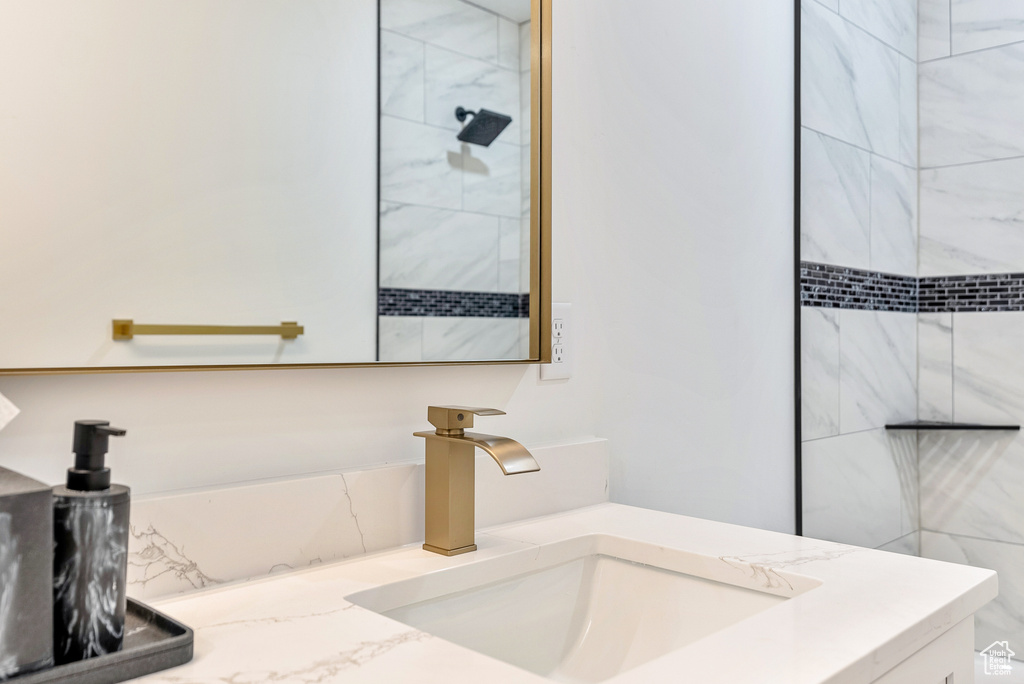 Bathroom with tiled shower and vanity