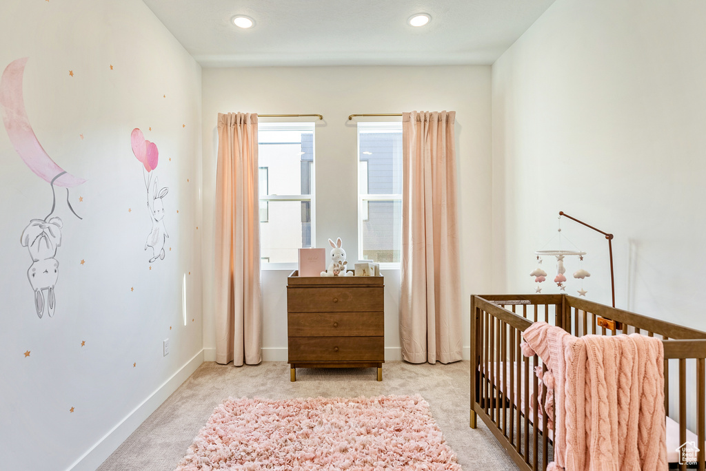 Bedroom with light carpet and a nursery area