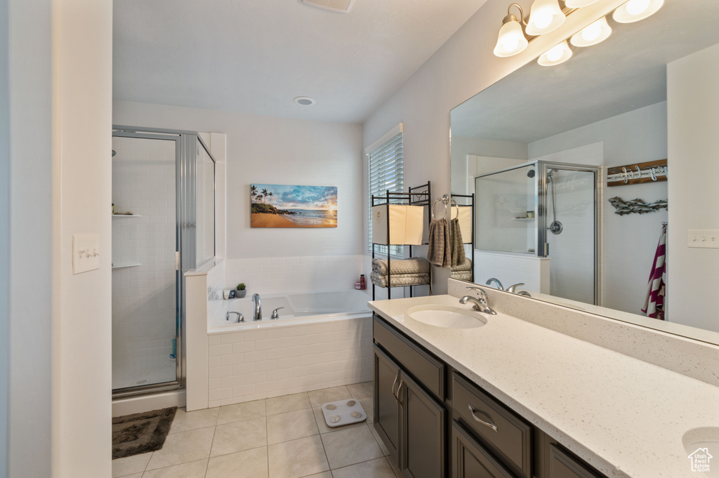 Bathroom featuring separate shower and tub, tile patterned floors, and vanity