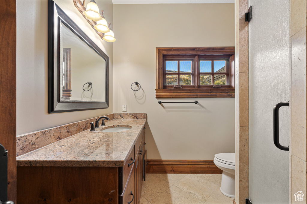 Bathroom featuring vanity, tile patterned flooring, and toilet