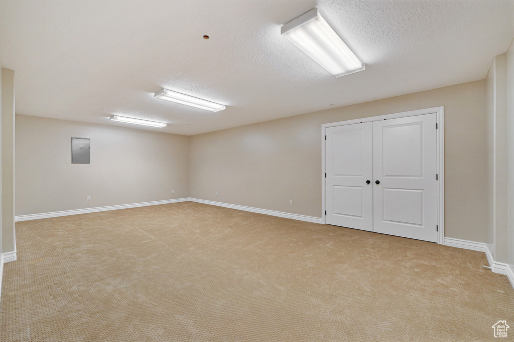 Empty room with a textured ceiling and light carpet