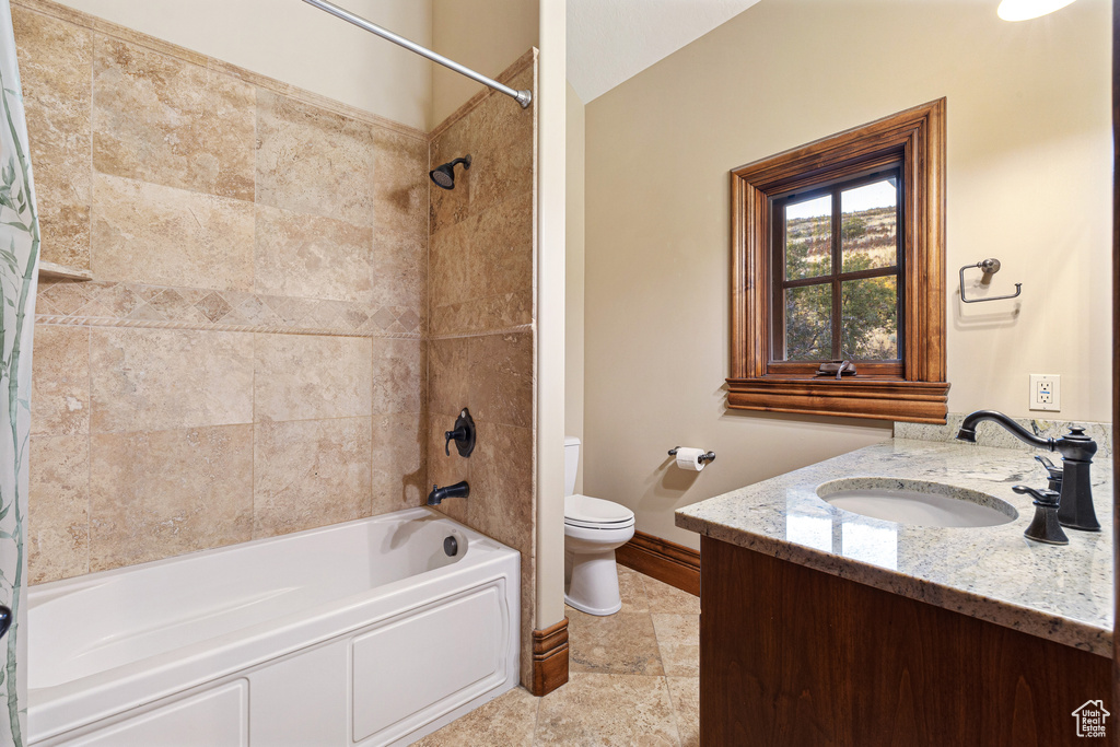 Full bathroom featuring vanity, toilet, and shower / bathtub combination with curtain