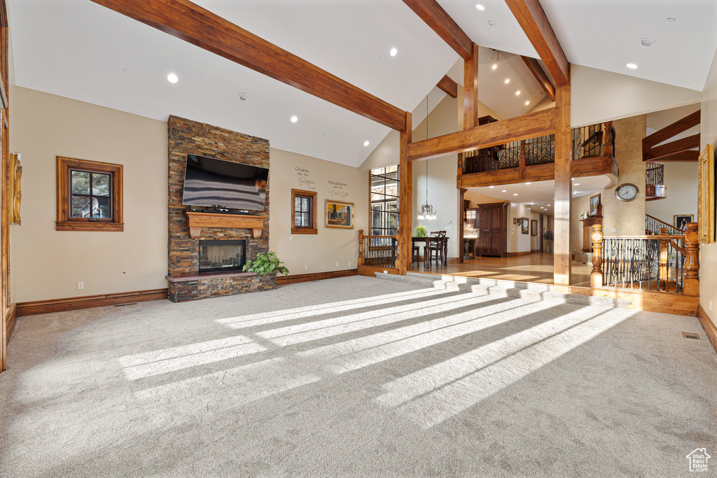 Unfurnished living room featuring beamed ceiling, carpet, and high vaulted ceiling