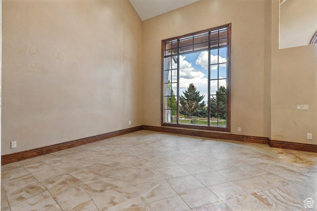 Empty room featuring lofted ceiling