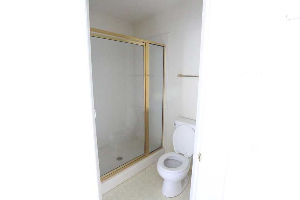 Bathroom featuring an enclosed shower and toilet