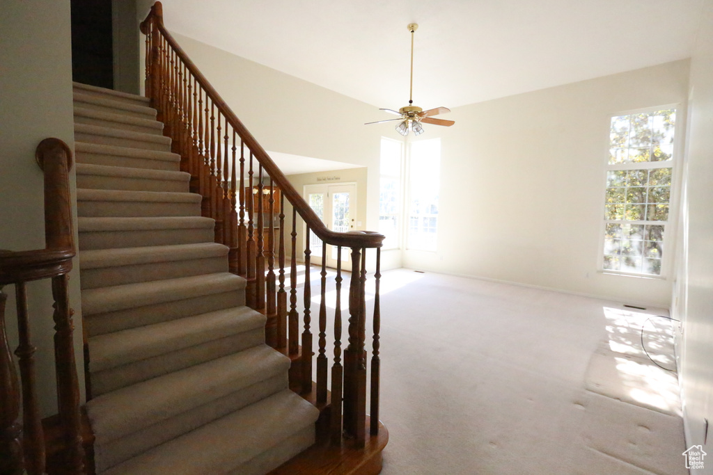 Stairway with carpet floors and ceiling fan