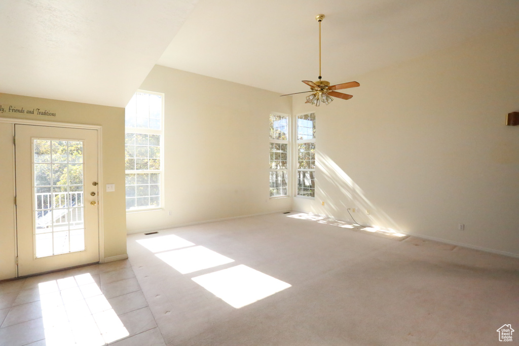 Unfurnished living room with light colored carpet and ceiling fan