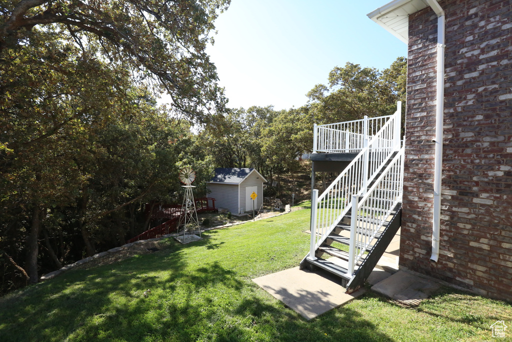 View of yard featuring a deck and a storage shed