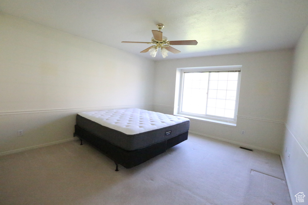 Carpeted bedroom with ceiling fan