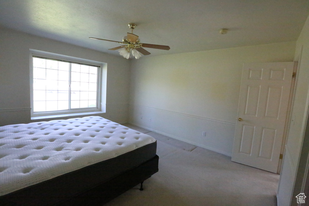 Carpeted bedroom with ceiling fan