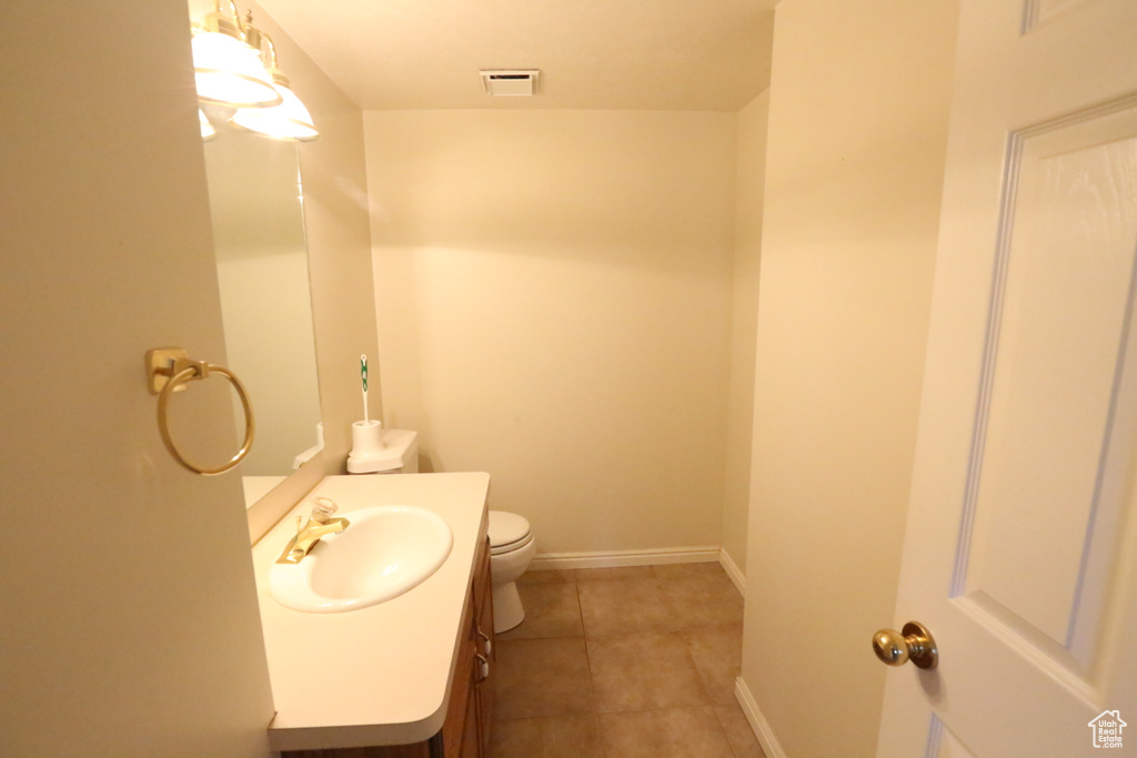 Bathroom featuring tile patterned flooring, vanity, and toilet