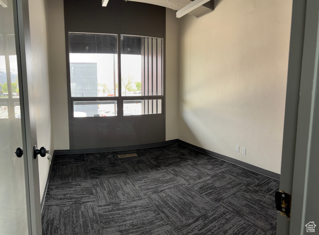 Carpeted empty room with a healthy amount of sunlight and baseboards