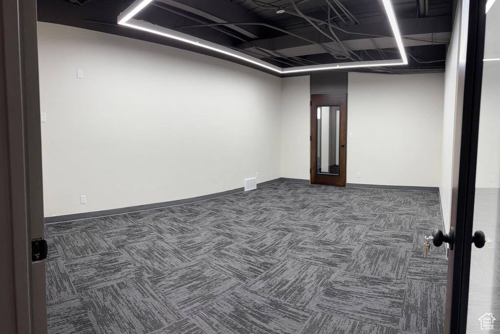 Spare room featuring carpet floors and baseboards