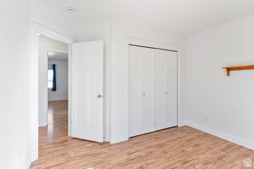 Unfurnished bedroom featuring a closet and light wood-type flooring