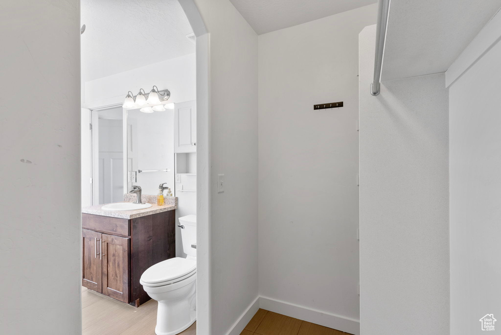 Bathroom with wood-type flooring, vanity, and toilet