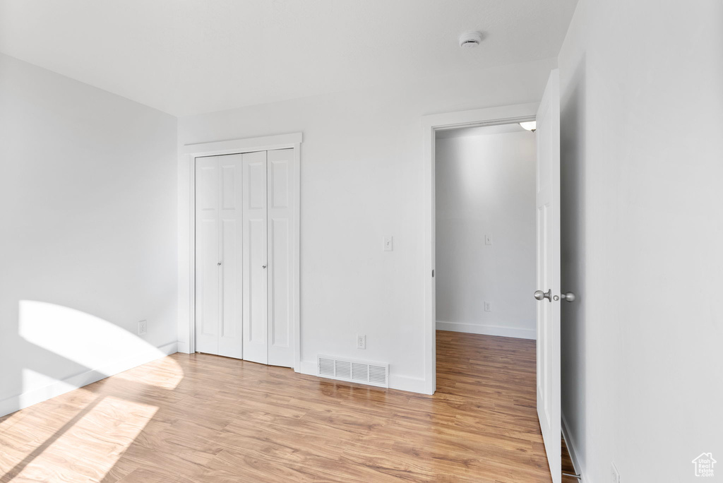 Unfurnished bedroom with a closet and light wood-type flooring