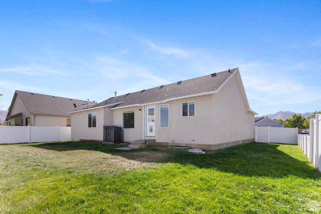 Rear view of property with a yard and a mountain view