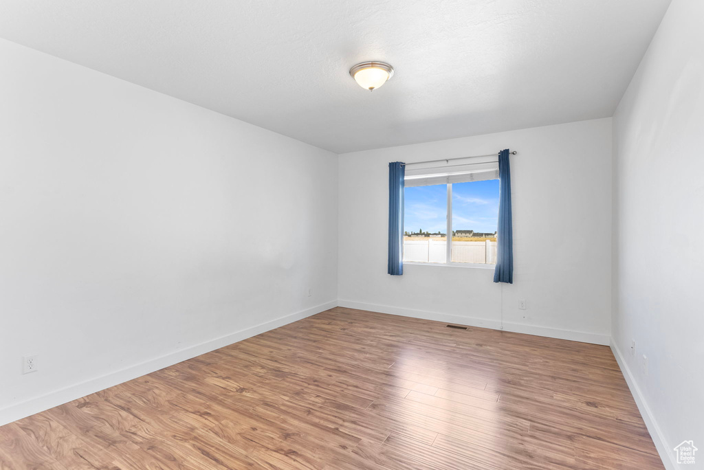 Spare room featuring wood-type flooring