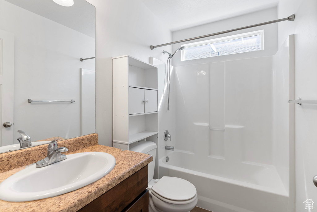 Full bathroom with vanity, toilet, and  shower combination