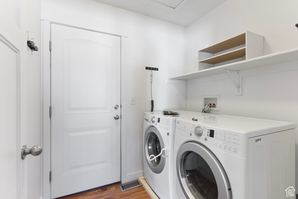 Washroom featuring washer and clothes dryer and wood-type flooring