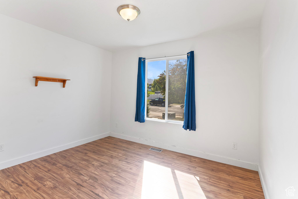 Empty room with hardwood / wood-style floors