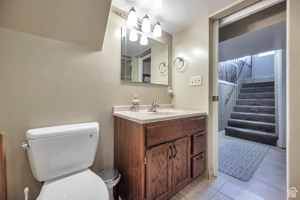 Bathroom featuring tile patterned floors, vanity, toilet, and a shower