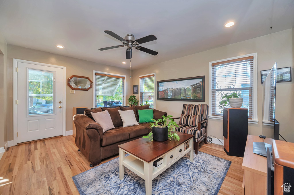 Living room with ceiling fan and light hardwood / wood-style floors