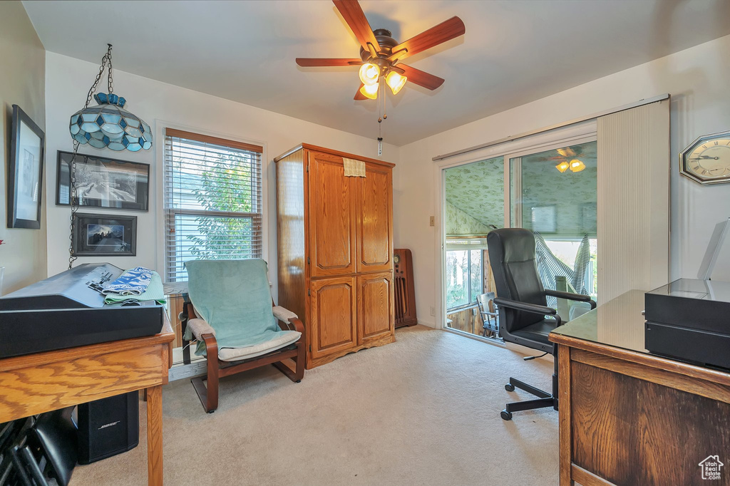 Carpeted home office featuring ceiling fan