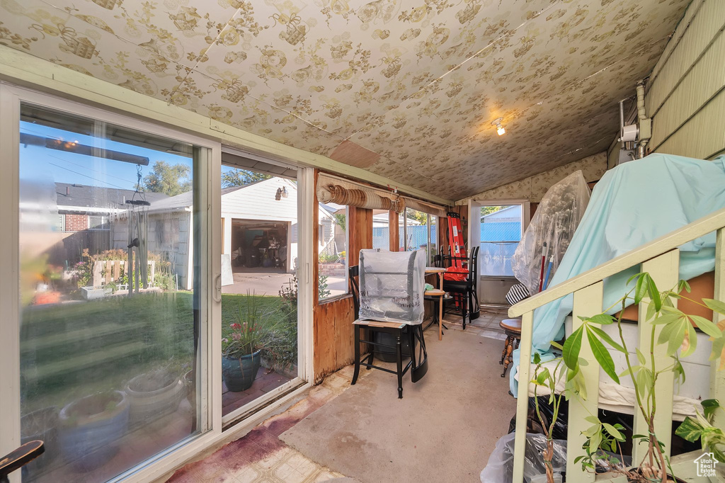 Unfurnished sunroom featuring vaulted ceiling