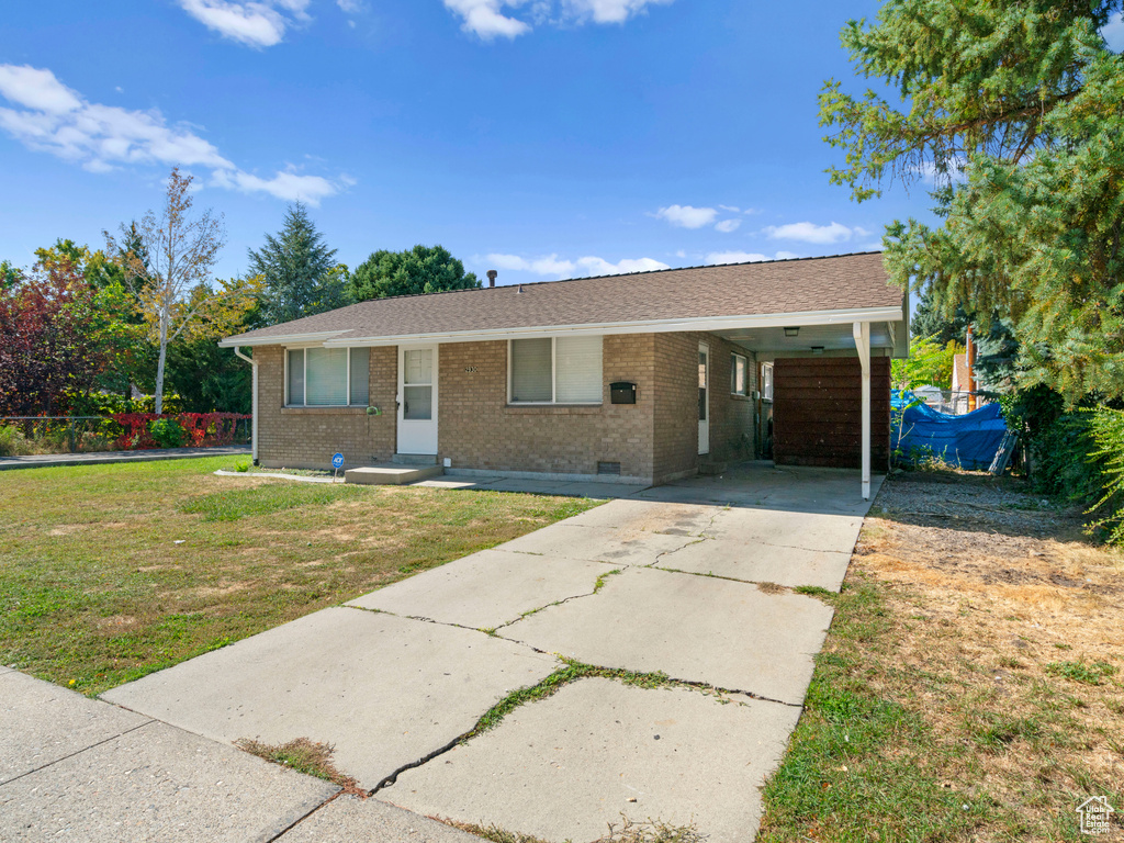 Ranch-style house featuring a front lawn and a carport